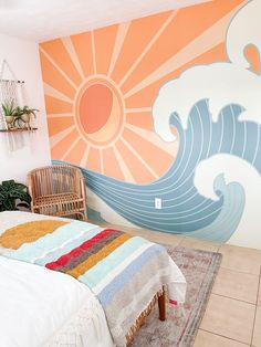 a room with a bed, chair and wall mural on the walls that has waves painted on it