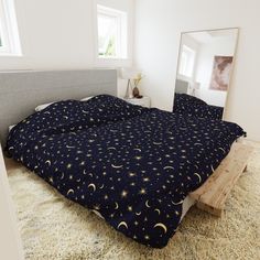 there is a bed that has been made with stars and moon designs on it in the room