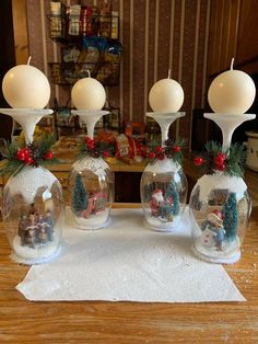 three glass vases with christmas decorations in them