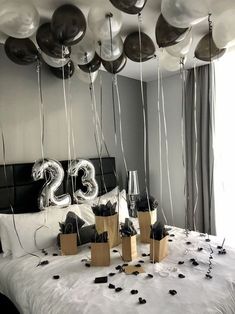 balloons and streamers fill the air above a bed with black and white decorations on it