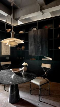 a dining room with black walls and chairs