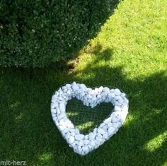 a heart made out of rocks sitting in the grass