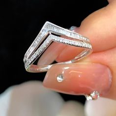 a woman's hand holding a diamond ring with diamonds on the bottom and sides