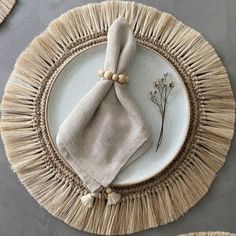 a plate with a napkin on top of it and some flowers in the middle next to it