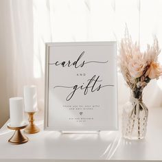 a vase filled with flowers next to a card and gifts sign on top of a table