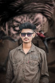 a man wearing sunglasses standing in front of a tiger