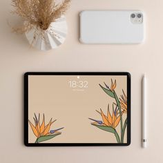 a tablet with an image of birds of paradise on it next to a pen and phone