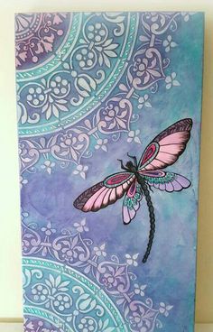 a purple and blue painting with a dragonfly on it's wings, sitting on a