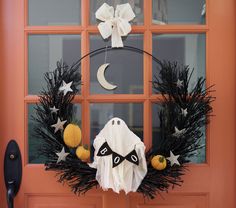 a halloween wreath is hanging on the front door