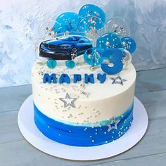 a blue and white birthday cake with a car on top