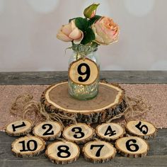 a vase filled with flowers sitting on top of a wooden table next to numbered numbers