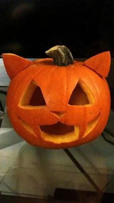 an orange pumpkin with a cat's head carved into it