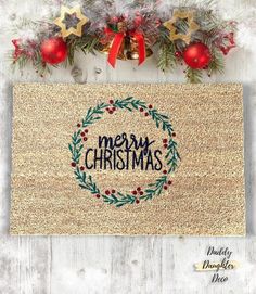 a christmas door mat with the words merry christmas written on it and decorations around it