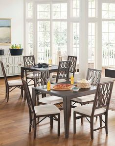 a dining room table with chairs and a pizza on it