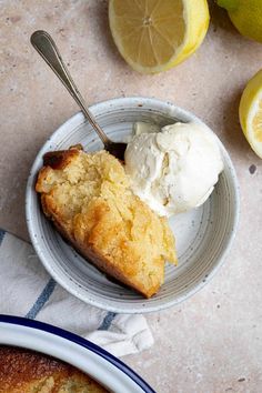 a bowl with some ice cream on top of it next to lemons and bread