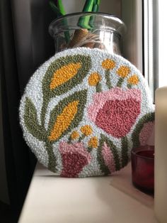 a vase filled with flowers sitting on top of a counter next to a candle holder