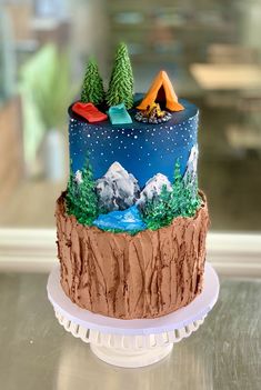 there is a cake decorated with trees and mountains