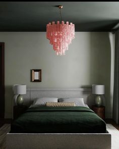 a bedroom with a large bed and pink chandelier