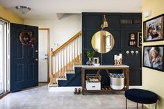 an entryway with blue doors and pictures hanging on the wall, along with a console table