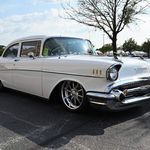 an old white car parked in a parking lot