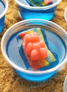 four plastic bowls filled with different colored desserts on top of a carpeted floor