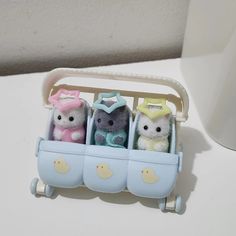 three small stuffed animals sitting in a toy car