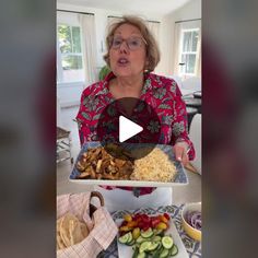 a woman holding a tray with food on it