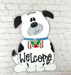 a sign that says welcome with a dog wearing a bow tie on it's collar