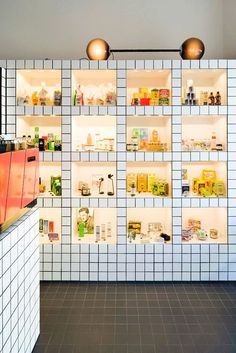 a tiled wall with shelves and lights above it