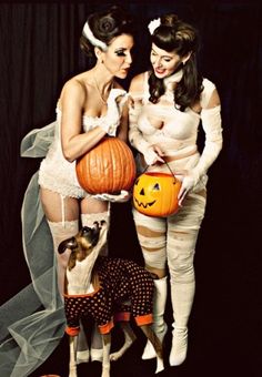 two women dressed up in halloween costumes holding pumpkins and posing for an instagram