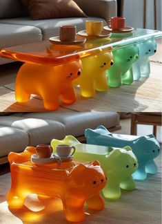 three colorful glass bears sitting on top of a wooden table next to a gray couch