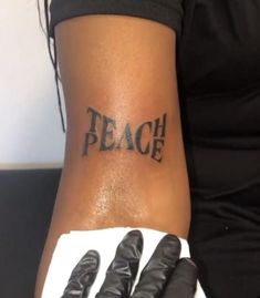 a woman's arm with gloves on it and the word peace written in black ink