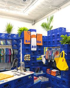 a blue rack filled with lots of items next to a white table and planters