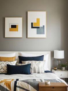 a bedroom with two paintings on the wall above the bed and nightstand next to it