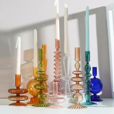 there are many different colored candles on the table