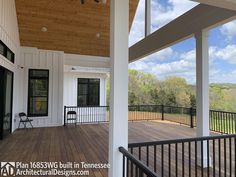 an open porch with black railings and wood flooring on the side of a house