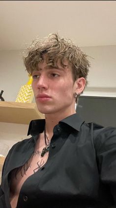 a young man with curly hair wearing a black shirt