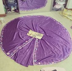 there is a purple cloth on the floor in front of a mirror with an upside down umbrella