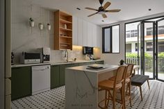 a kitchen with green cabinets and white tile flooring next to a sliding glass door