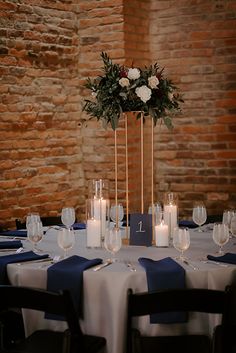 the table is set with candles, flowers and wine glasses for an elegant centerpiece