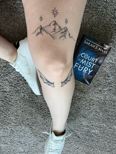 a woman's leg with a tattoo on it and the words court of mist fury