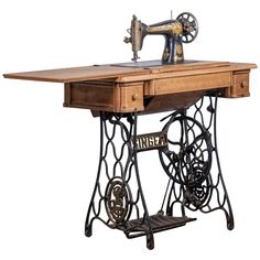 an old fashioned sewing machine sitting on top of a wooden table