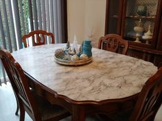 a marble dining table with chairs around it