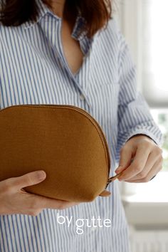 a woman holding a brown purse in her hands