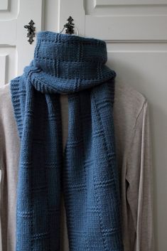 a blue scarf hanging on a white door