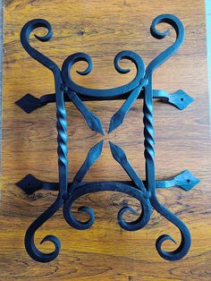 an ornate iron design on a wooden surface