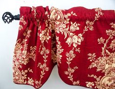 red and gold floral curtain with black handle