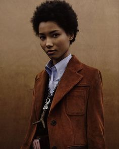 a young man in a brown jacket and tie