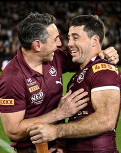 two rugby players are hugging each other on the field