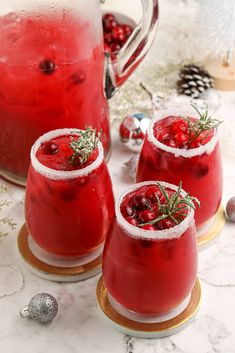 three glasses filled with cranberry punch and garnished with rosemary